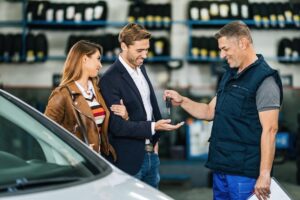 Happy couple receiving car keys from a mechanic